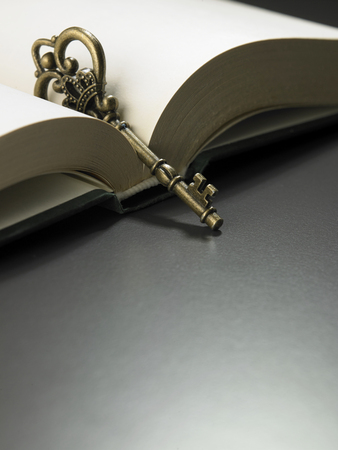 retro golden key on thick hard cover bookの写真素材