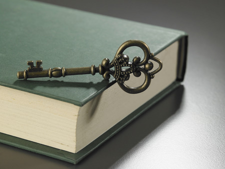 retro golden key on thick hard cover bookの写真素材