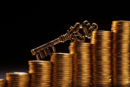 key resting on the stack of coinの写真素材