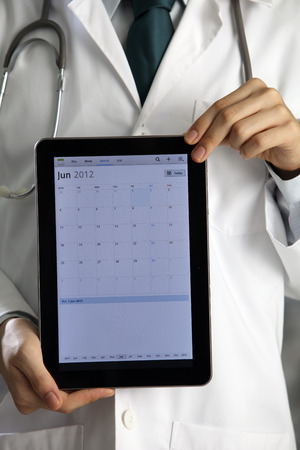 Doctor holding and showing digital tablet.の写真素材