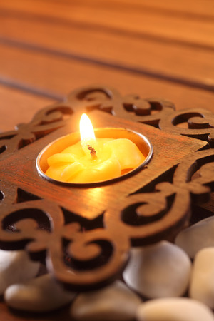 Candle with asian design on stoneの写真素材