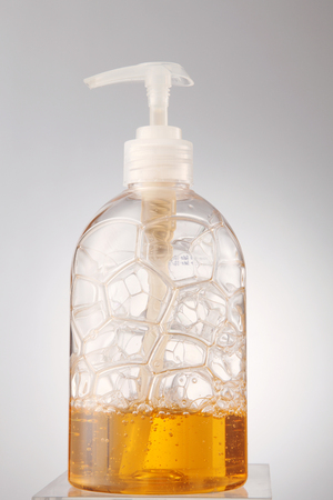 bubble of yellow color soap in the dispenserの写真素材