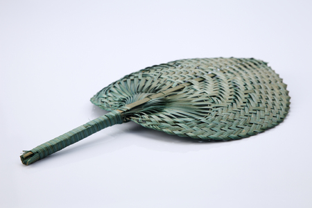 Green color native fan made from palm leaves on white backgroundの写真素材