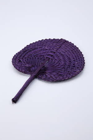 Purple color native fan made from palm leaves on white backgroundの写真素材