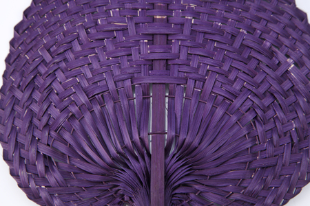 Purple color native fan made from palm leaves on white backgroundの写真素材