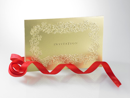 golden invitation card with ribbonの写真素材