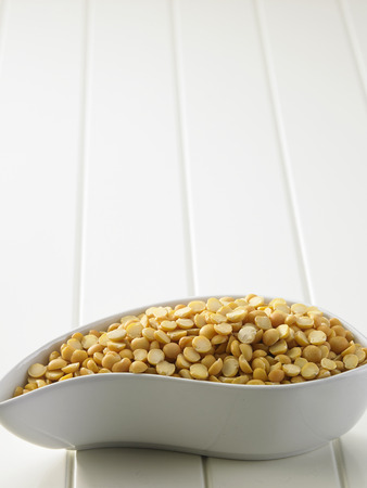 yellow lentils on the white wooden tableの写真素材