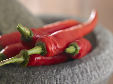 red chilli and morthar on the wooden tableの写真素材