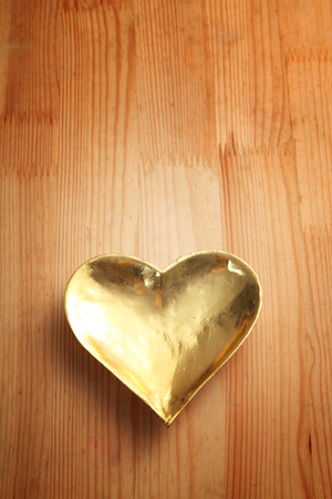 golden color heart shape saucer or plateの写真素材
