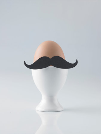 Easter egg with moustache in egg cup