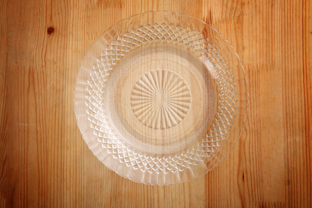 top view of glass plate or saucer on the wooden backgroundの写真素材