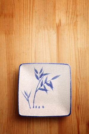 top view of the square japanese saucer on the wooden backgroundの写真素材