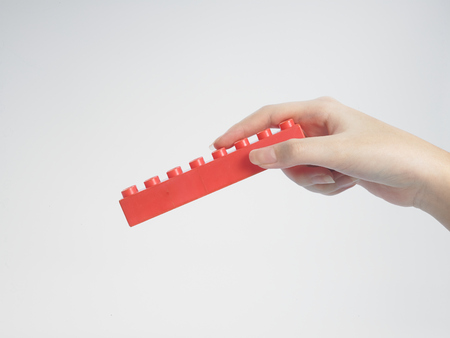 female hand holding a plastic building pieceの写真素材