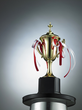 classic golden trophy on the gray background with light effectの写真素材