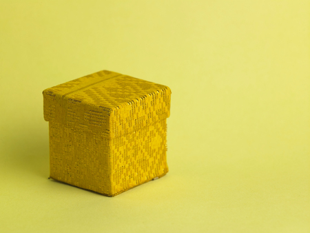 closed yellow gift box on the yellow backgroundの写真素材