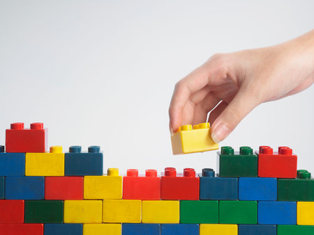 hand stack up block set as a wall on white background