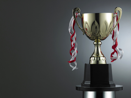 classic golden trophy on the gray background with light effectの写真素材