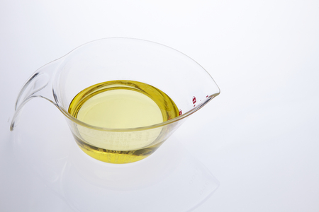 Pouring vegetable cooking oil into a clear glass bowlの写真素材