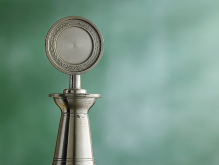 old pewter trophy in front of blackboardの写真素材
