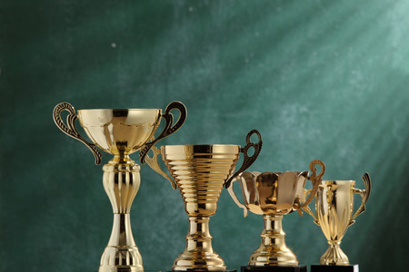 group trophies in front of blackboard with light ray effectの写真素材