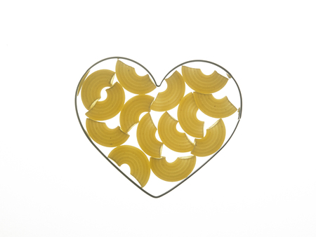 macaroni pasta in a heart shape mold with back lightingの写真素材