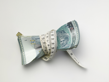 stack of malaysia ringgit tight with measuring tapeの写真素材