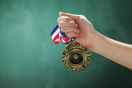 man holding a medal in front of blackboardの写真素材