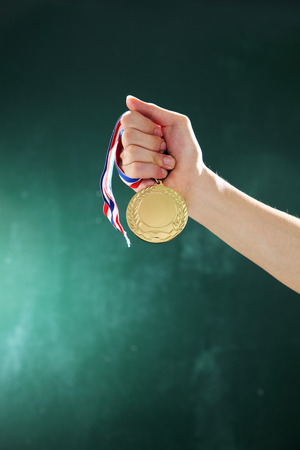 man holding a medal in front of blackboardの写真素材