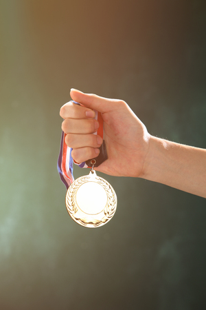 man holding a medal in front of blackboardの写真素材