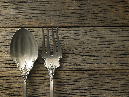 antique fork and spoon on the wooden backgroundの写真素材