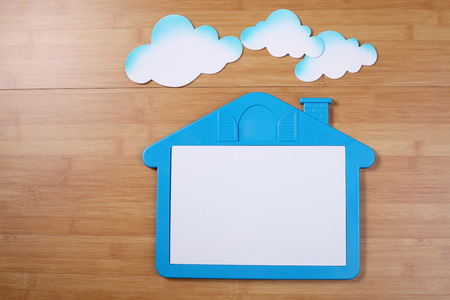 blank house shape whiteboard with cloud on the wooden backgroundの写真素材