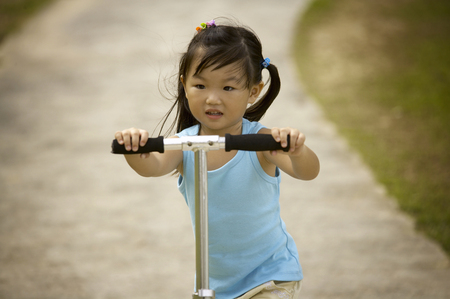 Girl riding on kick scooterの写真素材