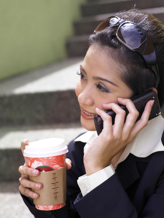 businesswoman on cellphone outdoorの写真素材