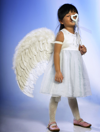 Happy kid covering her face with her magic stickの写真素材