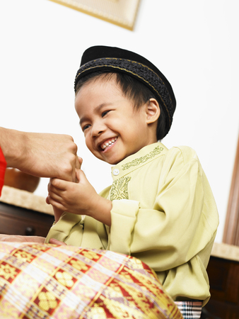 malay boy receiving blessing from parentの写真素材