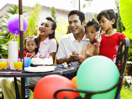 family celebrating birthday in the gardenの写真素材
