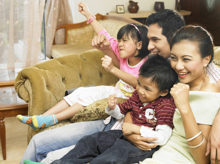 Family laughing together at the living areaの写真素材