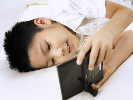 high angle view of boy playing portable video gameの写真素材