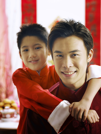 father and son posing to camera during chinese new yearの写真素材