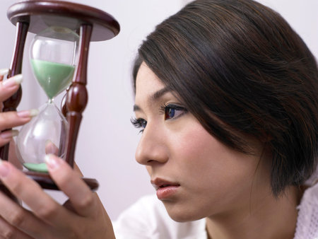 close up of woman holding a hourglass