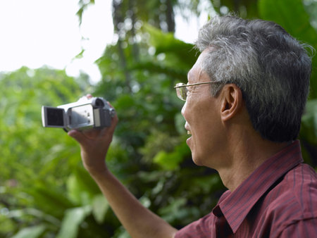 man holding a portable video doing recording