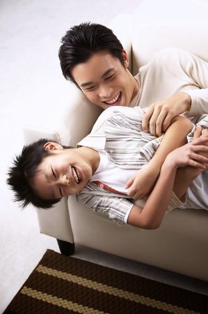 father and son having fun ath living hallの写真素材