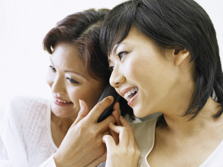 mother and daughter sharing listening on  phone setの写真素材