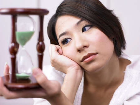close up of woman holding a hourglass