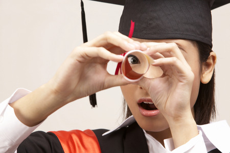 young graduate looking through the scrollの写真素材