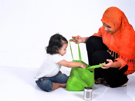 Mother teaching daughter to recycleの写真素材