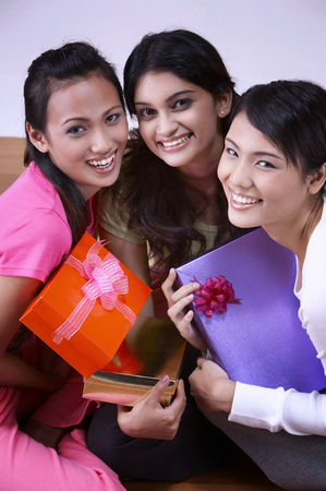3 young woman hold present to exchangeの写真素材
