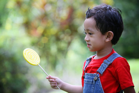Boy holding colourful lollipopの写真素材