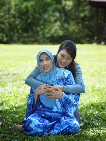 daughter hugging mother from the backの写真素材