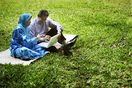 senior couple at park using laptopの写真素材